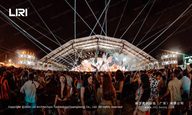 Full-span night view of a 50x30m outdoor festival tent with truss lighting, packed concert crowd, curved white PVC roof