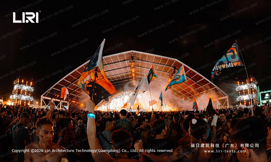 Stage perspective inside a 50x30m concert venue tent at night, dense audience, rigging visible overhead