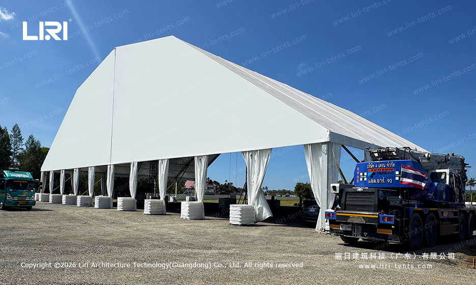 Full side profile of a 50x30m outdoor event tent, crane truck and palm trees provide true scale