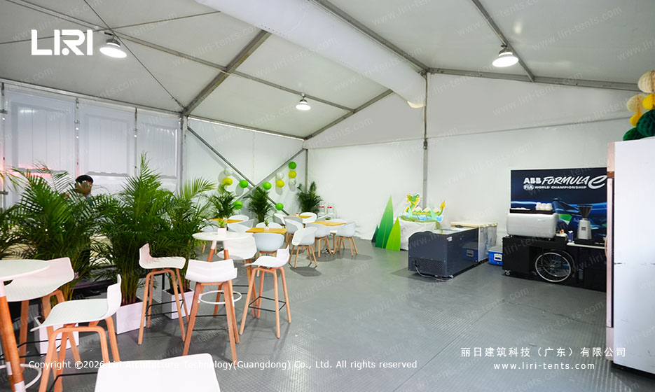 Green themed hospitality area with bar stools inside a small A-frame event tent