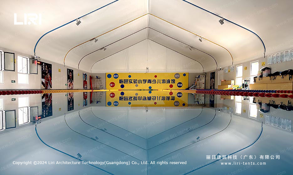 indoor swimming pool inside clear span tent with lane dividers and arched ceiling