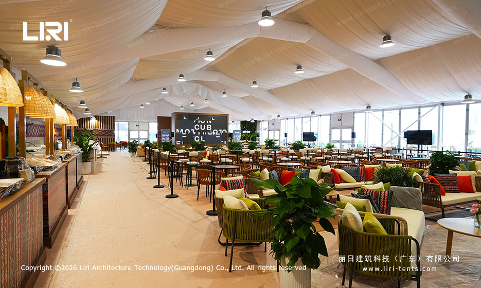 Large hospitality lounge with dining tables and embroidered fabric ceiling