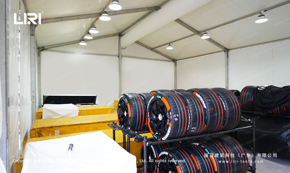 Formula E race tires stored on racks inside a small A-frame support tent