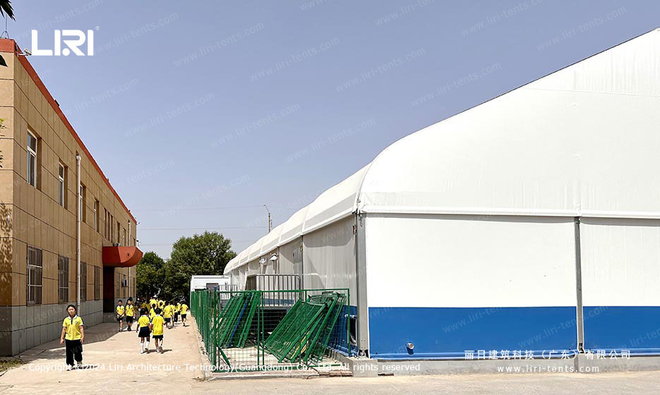 clear span swimming pool tent exterior side view next to school building