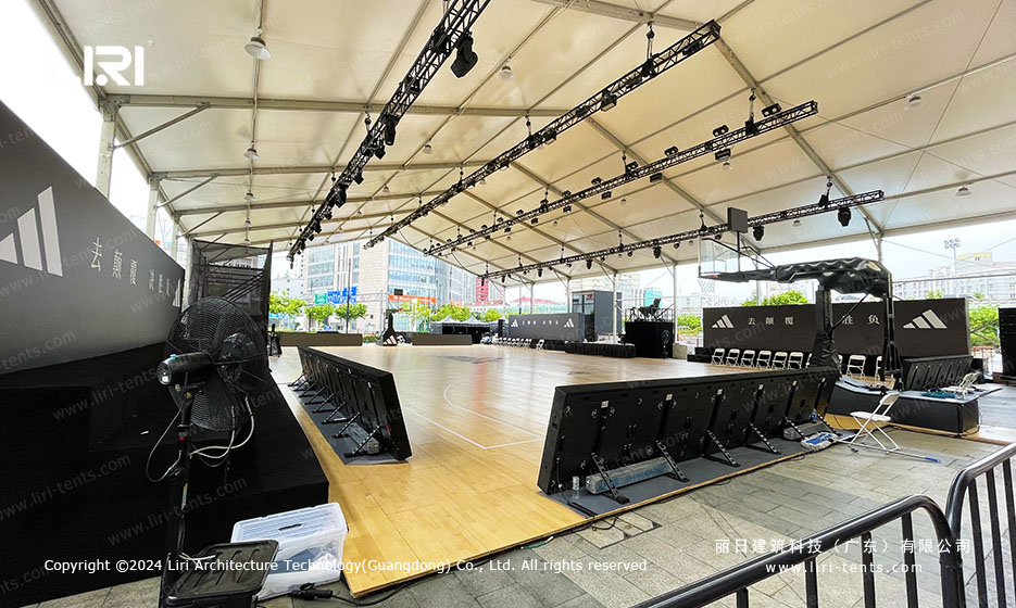 Sports event tent interior showing LED display wall and court-side barriers