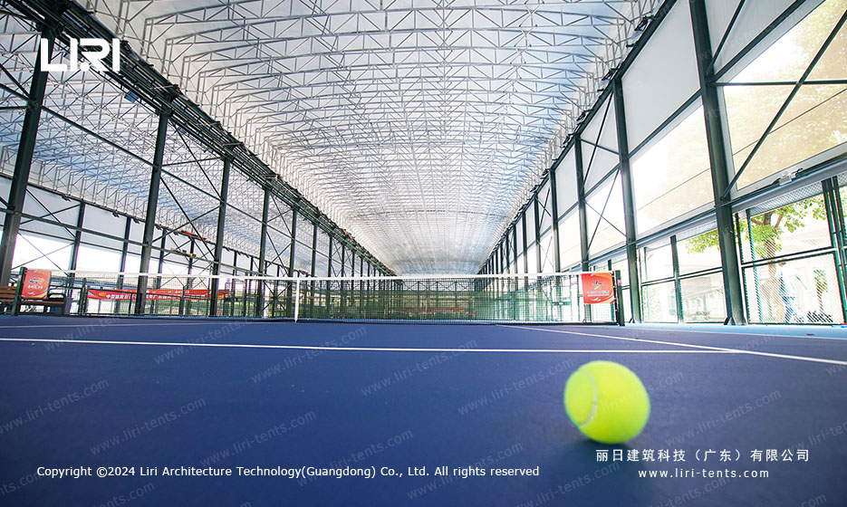 Tennis ball on court surface under clear span roof