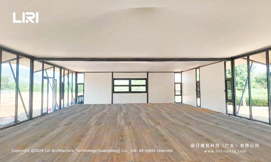 Tensile membrane party tent interior with glass walls and wooden flooring