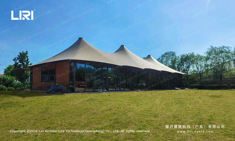 Tensile membrane party tent installed on green lawn