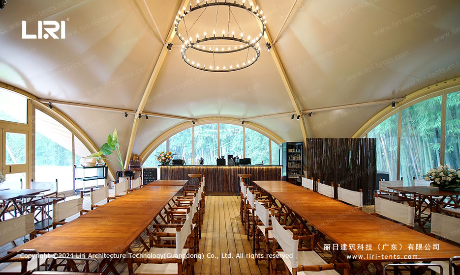 Tipi event space with wooden tables and panoramic windows