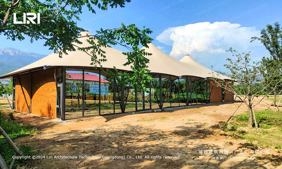 Triple peak tent structure in a resort landscape