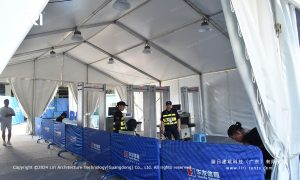 white event tent interior with security checkpoint and walk-through metal detector gates