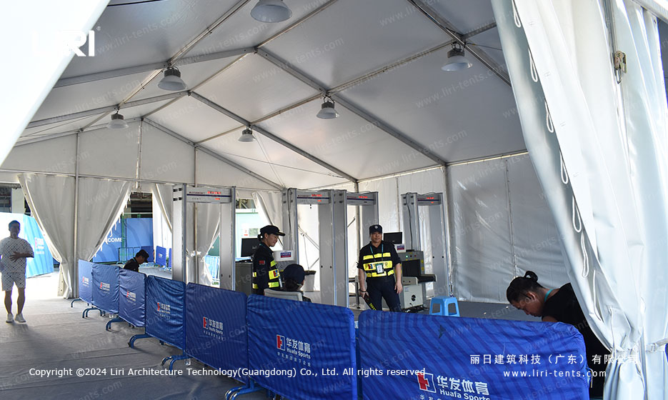 white event tent interior with security checkpoint and walk-through metal detector gates