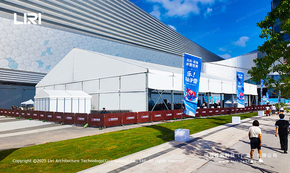 Front aerial view of an opening ceremony party tent installed on a Shenzhen urban plaza with banner flags and ice block entry decoration for a winter brand launch