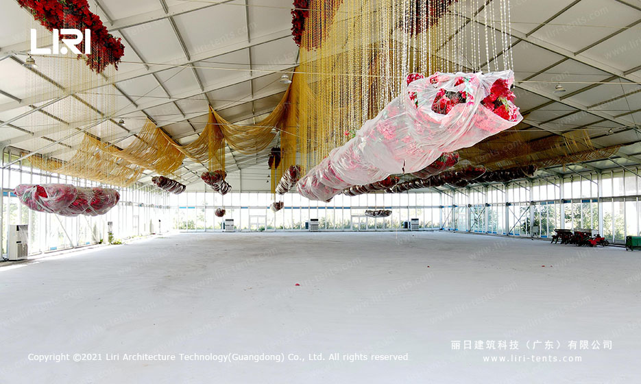 interior of large wedding tent with hanging floral installations