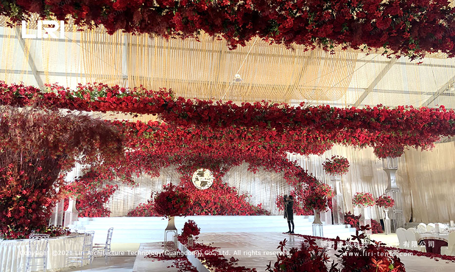 wedding reception hall with red flower ceiling decorations