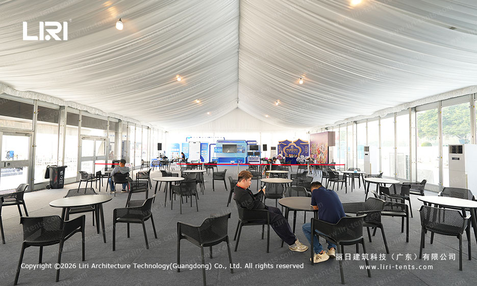 Round dining tables and chairs inside the white festival party tent