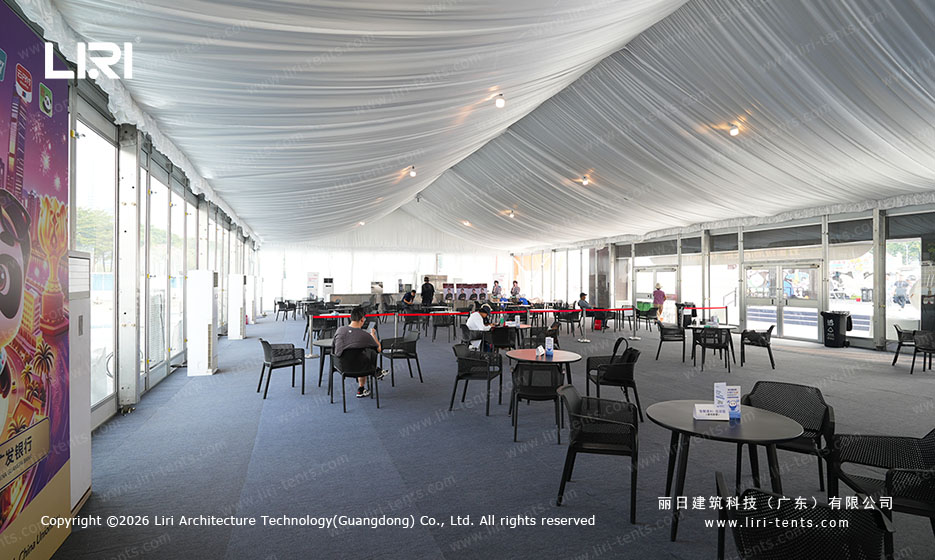 Long view across covered seating and the side openings of the festival tent